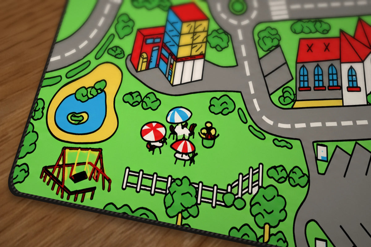 Close-up of the mat corner showing the stitched black edge and the park, pond and playground in the print